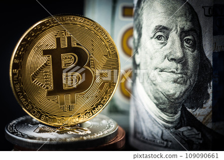 Bitcoin coin standing in front of dollar bills Bitcoin coin standing in front of dollar bills 109090661
