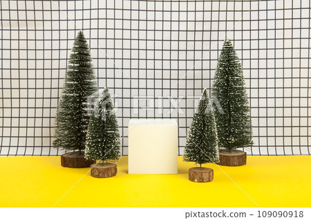 white wooden cube surrounded by several miniature christmas trees 109090918