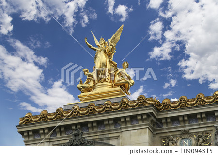 Golden statue of Liberty on the roof of the Opera Garnier (Garnier Palace) against the sky with clouds. Sculpted by Charles Gumery in 1869. Paris, France. UNESCO World Heritage Site Golden statue of Liberty on the roof of the Opera Garnier (Garnier Palace) against the sky with clouds. Sculpted by Charles Gumery in 1869. Paris, France. UNESCO World Heritage Site 109094315