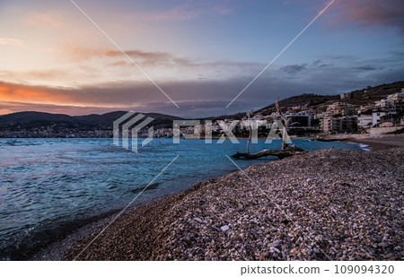Sarande beach during sunset. Bistrica Beach with view at Sarande city. beautiful evening sky Sarande beach during sunset. Bistrica Beach with view at Sarande city. beautiful evening sky 109094320