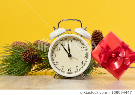 Alarm clock and stack of red gift boxes on yellow background 109094447