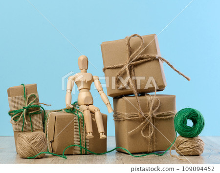 The box is packed in brown craft paper and tied with a rope on a blue background, gift 109094452
