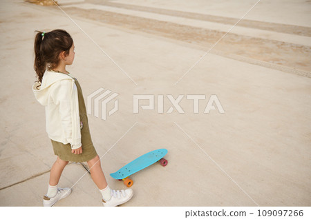 Little child girl skateboarding on urban skatepark. Top view. Happy active childhood. Extreme sport. Leisure activity 109097266
