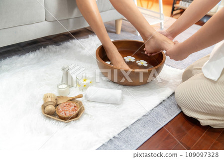 Woman indulges in blissful foot massage at luxurious spa salon. Quiescent Woman indulges in blissful foot massage at luxurious spa salon. Quiescent 109097328