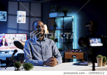 Smiling influencer preparing to start recording content for social media channel. BIPOC internet show host ready to begin filming using professional camera and microphone 109098312