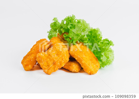 Breaded Chicken Inner Fillet with green lettuce leaves on a White Background,Chicken Breaded Raw Meat,Fillet.Breaded chicken nuggets. Fast homemade food at home.Chicken breaded schnitzels.Fast cooking 109098359