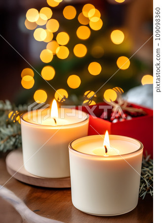 The warm glow of two wax candles on a table, evoking memories of christmas and creating a cozy ambiance 109098360