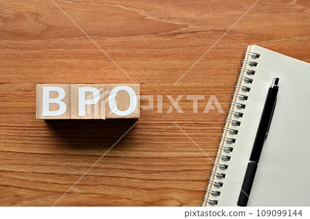 Wooden cubes, notebooks and pens lined up with BPO 109099144