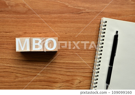 Wooden cubes, notebooks and pens lined up with MBO Wooden cubes, notebooks and pens lined up with MBO 109099160