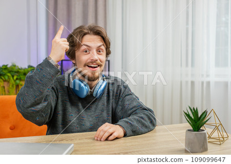 Thoughtful inspired Caucasian man make Eureka gesture raises finger came up creative plan at home 109099647