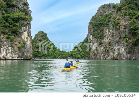People enjoying kayaking in Ha Long Bay, Vietnam, where the strange rocks continue 109100534