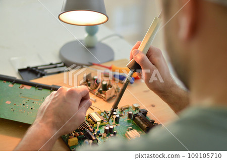 E-waste, technician repairing inside of hard disk by soldering iron. Integrated Circuit. the concept of data, hardware, technician and technology. 109105710