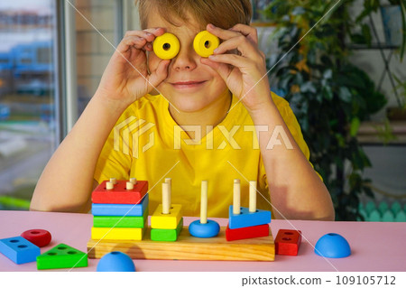 eco wooden toys. The child collects a sorter. Educational logic toys for kids. Games for Child Development 109105712