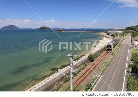 Tsushima Shrine, a guardian deity for children floating on the sea in Mino-cho, Mitoyo City, Kagawa Prefecture, and local trains on the JR Yosan Line running in Setouchi 109107003
