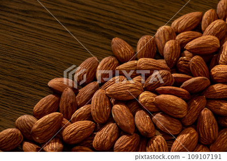 a lot of almonds on a wooden table 109107191