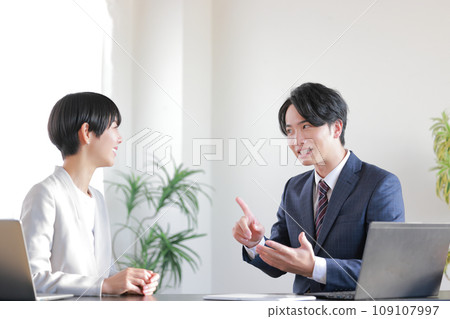 A businessman says, "I have one concern," and a businesswoman smiles and listens.1 A businessman says, "I have one concern," and a businesswoman smiles and listens.1 109107997