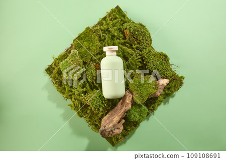A green bottle mockup for cosmetic displayed on green moss with dried branch tree on pastel green background. Minimal scene for advertising cosmetic with natural concept A green bottle mockup for cosmetic displayed on green moss with dried branch tree on pastel green background. Minimal scene for advertising cosmetic with natural concept 109108691