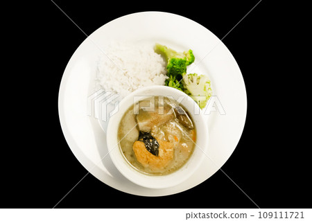 Top view of Thai Green Curry Vegan with rice on black background. 109111721