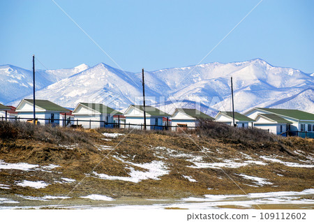 Many identical houses for camping and basing at the foot of the snowy mountains. Far East, Russia Many identical houses for camping and basing at the foot of the snowy mountains. Far East, Russia 109112602
