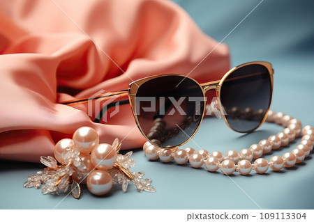 Sunglasses with pearl necklace near pink cloth on pastel background. Sunglasses with pearl necklace near pink cloth on pastel background. 109113304