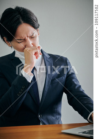 Young male office worker holding his nose with his finger Young male office worker holding his nose with his finger 109117582