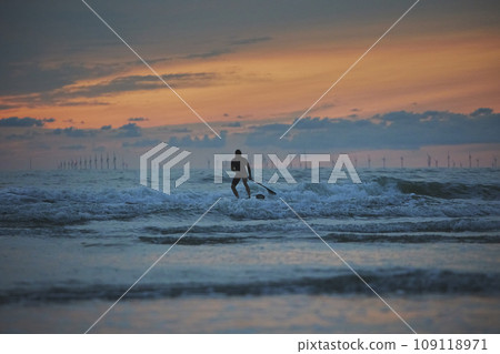 Surfer in the North Sea in the Netherlands at night Surfer in the North Sea in the Netherlands at night 109118971