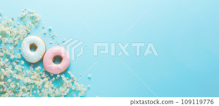 Delicious donuts and delicate white bouquet of flowers on light blue background. Top view, banner Delicious donuts and delicate white bouquet of flowers on light blue background. Top view, banner 109119776