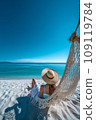 Beautiful girl in hat on sandy beach. Woman on seashore relaxing on swing on vacation 109119784