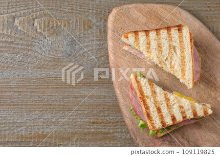 Tasty sandwich with ham on wooden table, top view. Space for text 109119825