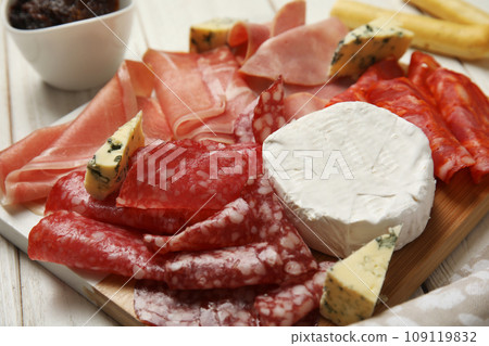 Tasty ham with other delicacies served on white wooden table, closeup Tasty ham with other delicacies served on white wooden table, closeup 109119832