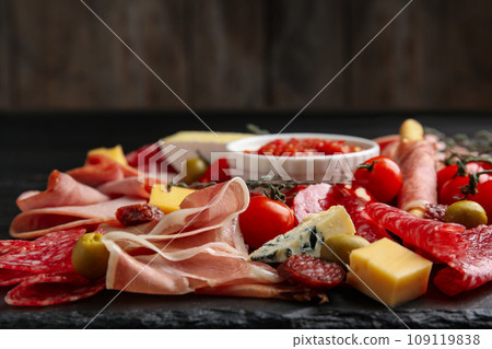 Tasty prosciutto with other delicacies served on table, closeup 109119838