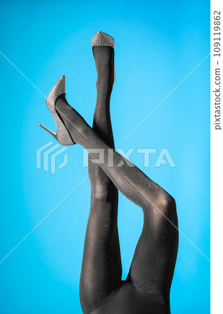 Woman wearing black tights and stylish shoes on blue background, closeup of legs 109119862