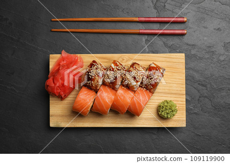 Delicious sushi rolls on dark grey table, flat lay 109119900