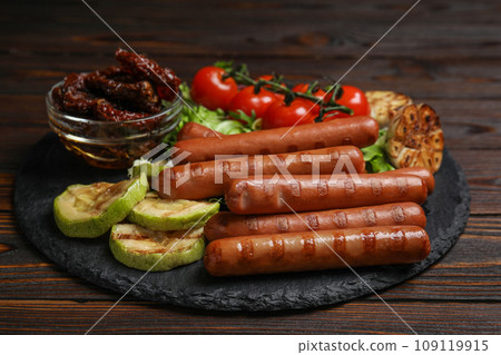 Delicious grilled sausages served on wooden table 109119915