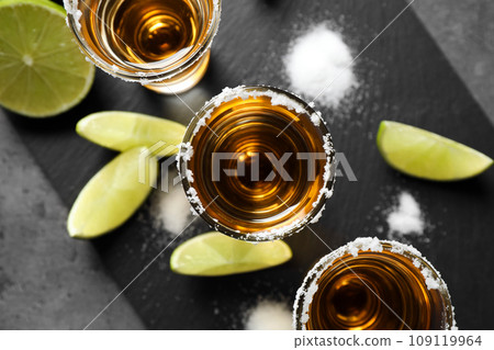 Mexican Tequila shots with salt and lime on grey table, top view 109119964