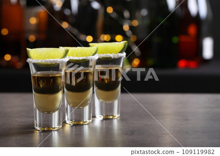 Mexican Tequila shots, lime slices and salt on bar counter. Space for text 109119982