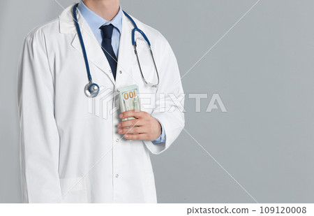 Doctor with bribe on grey background, closeup. Corruption in medicine 109120008
