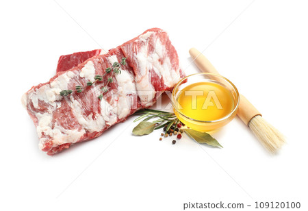 Raw ribs with herbs and oil on white background 109120100