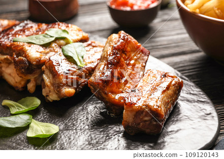 Delicious grilled ribs served on table, closeup Delicious grilled ribs served on table, closeup 109120143