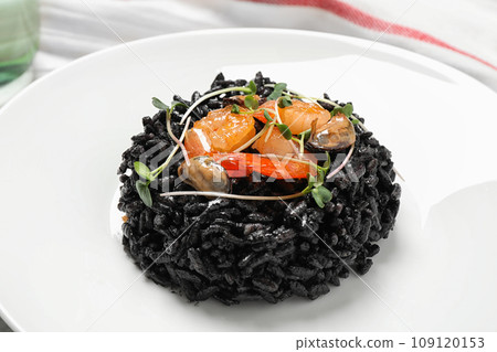 Delicious black risotto with seafood in plate, closeup 109120153