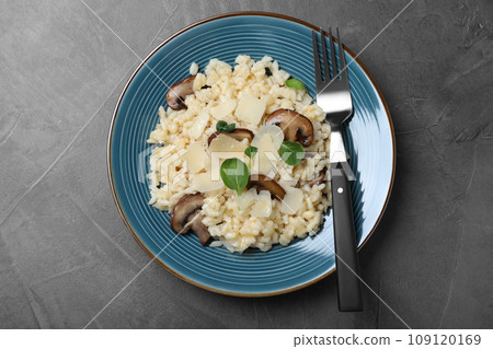 Delicious risotto with cheese and mushrooms on dark grey table, top view 109120169