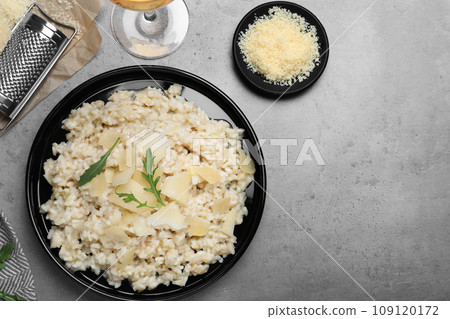 Delicious risotto with cheese on grey table, flat lay Delicious risotto with cheese on grey table, flat lay 109120172