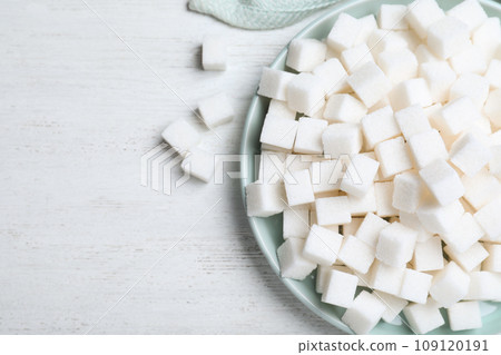 Refined sugar cubes on white wooden table, flat lay 109120191