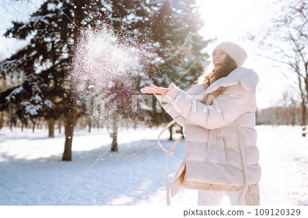 Happy woman in winter style clothes walking in the snowy park. Nature, holidays, travel concept. Happy woman in winter style clothes walking in the snowy park. Nature, holidays, travel concept. 109120329