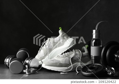 Gym equipment and accessories on stone floor against dark background 109120422
