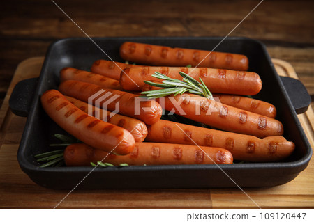 Delicious grilled sausages with rosemary on wooden table Delicious grilled sausages with rosemary on wooden table 109120447