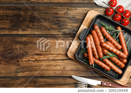 Tasty grilled sausages served on wooden table, flat lay. Space for text Tasty grilled sausages served on wooden table, flat lay. Space for text 109120449