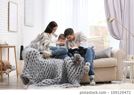 Happy family with little son reading books at home. Winter vacation 109120472