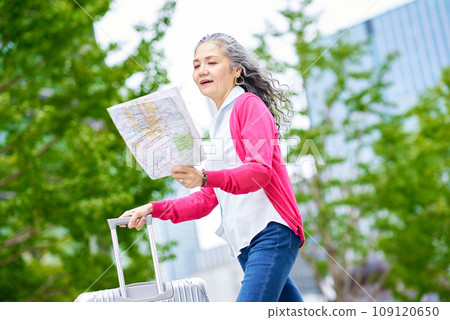 Senior woman walking with map in hand 109120650