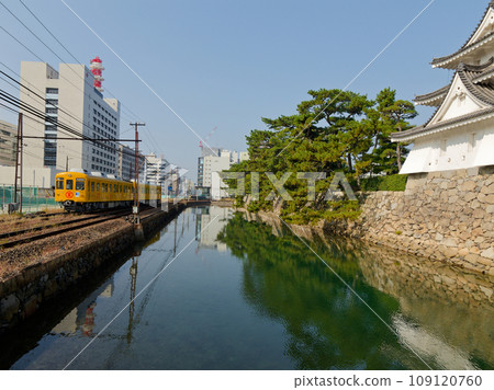 Takamatsu Kotohira electric railway train running along the middle moat of the historic Takamatsu Castle ruins Takamatsu Kotohira electric railway train running along the middle moat of the historic Takamatsu Castle ruins 109120760